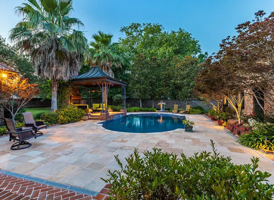 A pool surrounded by trees and bushes.