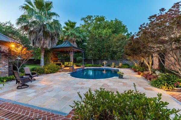 A pool surrounded by trees and bushes.