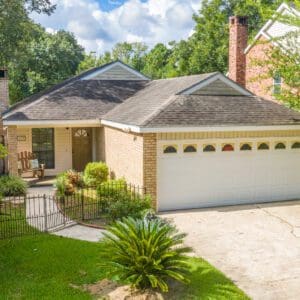 A house with a driveway and trees in the background